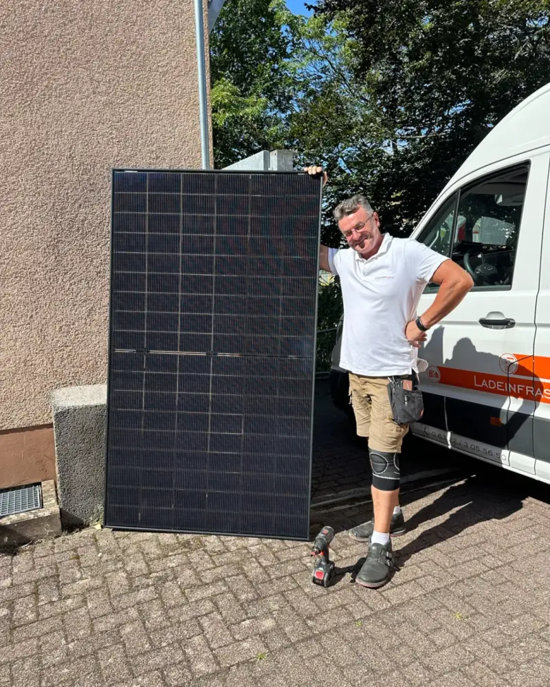 COPPEN-Monteur mit Solarmodul am Transporter